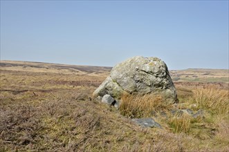 Pennine landscape with large old boulder or standing stone on midgley moor in west yorkshire