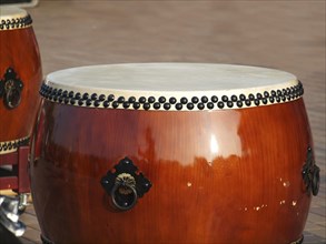 Two large traditional Chinese drums with brass handles and black tacks