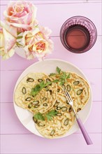 Pancakes with purple asparagus on a pink plate with roses