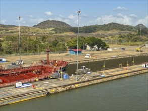 Ship in a lock in a canal, surrounded by industrial buildings, panama city, panamakanl, panama,