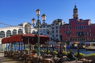 View of the Grand Canal, Rialto Bridge, and gondolas from outdoor restaurant seats, Venice, Italy,