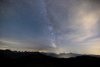 Clear starry sky with visible Milky Way and mountains in the background, Hochalp, Urnäsch,