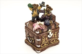 Old treasure chest topped by two little bears on a white background