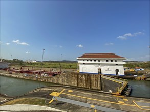 White lock building with red roof in an industrial canal area, panama city, panamakanl, panama,