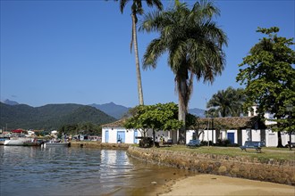 View to waterfront in historic town Paraty with colonial buildings, trees, sea and Atlantic forest