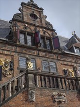 Historic Gothic brick building with decorative windows and coat of arms, nijmegen, netherlands