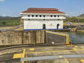 Panama Canal lock building surrounded by waterway and marked parking areas, panama city,