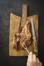 Man spiking a seared dry aged rib eye steak with a fork