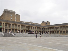 Halifax, west yorkshire, united kingdom, 12 july 2019: people walking and sat on the steps of the