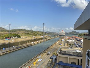 Cruise ship passing through a lock surrounded by industrial buildings, panama city, panamakanl,