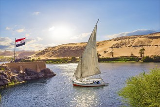 Egiptian flag and sailboat on river Nile in Aswan