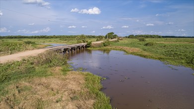 Aerial view of Transpantaneira wooden bridge crossing a river, sunny sky, Pantanal Wetlands, Mato