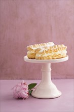 Eclairs with buttercream filling on a pink cake stand