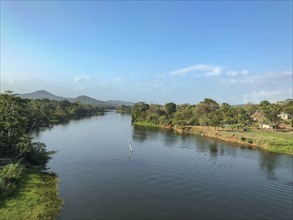 Calm river, surrounded by trees and mountains under a blue sky, panama city, panamakanl, panama,