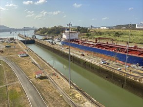 Large cargo ship crossing a canal with locks, industrial environment, panama city, panamakanl,