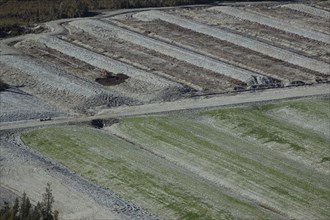 Diggers excavating land to make humps and hollows for farmland, West Coast, South Island, New