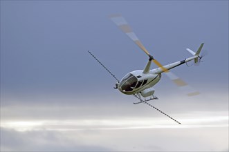 Helicopter spraying fertiliser on a crop in Westland, New Zealand, Oceania