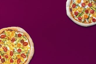 Above view with two homemade pizzas minimalist on a magenta colored table