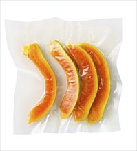 Vacuum sealed fresh papaya for sous vide cooking on white background cutout on white