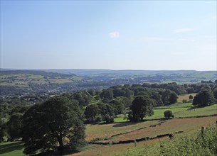 A scenic view of west yorkshire countryside with the town of sowerby visible at the bottom of the