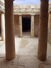 An underground chamber at the tombs of the kings in paphos cyprus with old eroded sandstone columns