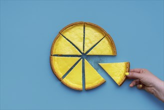 Top view with a cheesecake sliced in equal portions, minimalist on a blue background