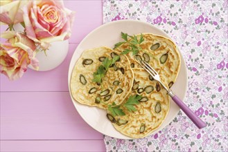 Pancakes with purple asparagus on a pink plate with roses