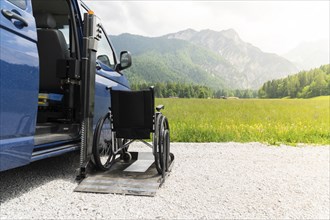 Photo of black electric lift specialized vehicle for people with disabilities. Empty wheelchair on