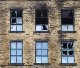 Broken windows in a large burned out old industrial building after a fire