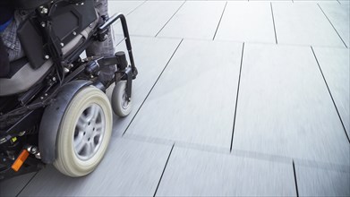 Man on electric wheelchair using a ramp. Accessibility concept