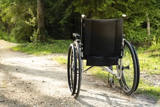 Photo of empty wheelchair parked in park, health care concept