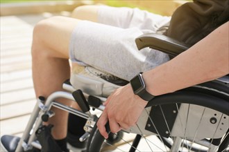 Disabled young athletic man on a wheelchair holding and turning wheels with hand engage in sports