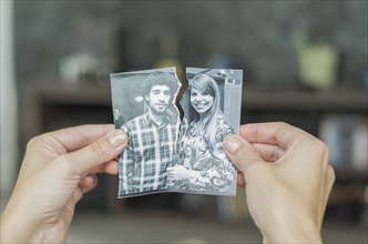 Great concept of divorce, betrayal, separation, woman hand ripping photo of the couple