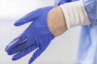 Surgeon doctor in sterile gloves preparing for operation in hospital. He is wearing surgical cap