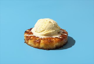 Summer dessert, roasted pineapple ring dipped in rum sauce, with a scoop of vanilla ice cream.