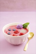 Raspberry smoothie bowl with blueberries, white chia seeds and raspberries in a bowl