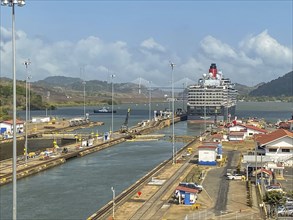 Cruise ship in a lock, surrounded by water and mountains under a blue sky, panama city, panamakanl,