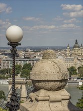 Stone lantern with a view of the cityscape and the river under a clear blue sky, budapest, danube,