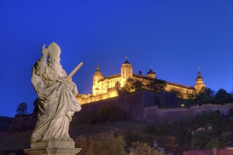 Figure of a saint on the Old Main Bridge with a view of Marienberg Fortress, Wuerzburg, Lower