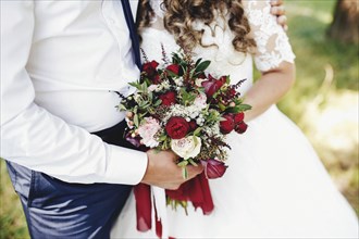 Bride and groom is holding wedding bouquet.