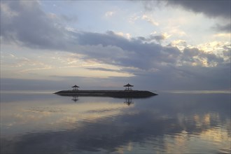 Beautiful seascape in the morning. Tropical sandy beach with breakwater and reflection of the sky