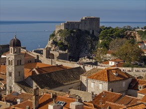 View of a town with red tiled roofs and a castle on the coast, dubrovnik, Mediterranean Sea,