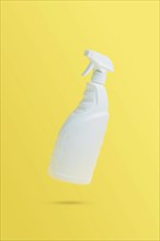 Levitation, flying blank toilet or window cleaner bottle with sprayer. Isolated on yellow