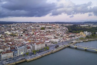 Coimbra drone aerial city view at sunset with Mondego river and beautiful historic buildings, in