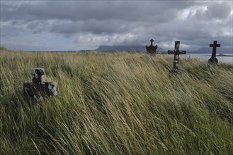 Crosses in a deserted graveyard along the seaside with Ben Bulben in the distant background. Sligo,