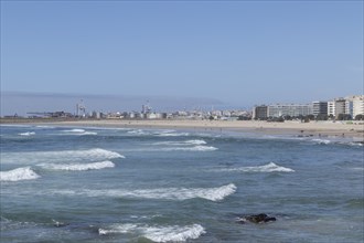 Town view with sandy beach and surf in the Atlantic Ocean at Praia de Matosinhos beach in