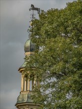 Spire of a church with a weather vane in the shape of a horse, dornum, east frisia, germany