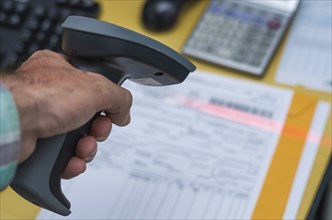 Hand reading the invoice barcode, stored data in the system, making payment