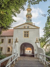 Tor tor with church tower above and decorative elements, offering a view of a building complex and