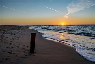 Den Helder, Netherlands. January 2022. Setting sun on the beach of Den Helder, Netherlands.